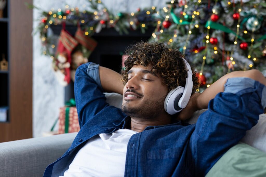 Weihnachtshörbücher: Mann auf dem Sofa mit Kopfhörern