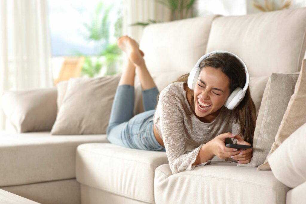 Comedy-Hörbücher: Frau lacht auf dem Sofa